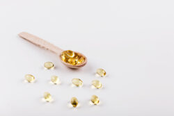 lepel met omega 3 visolie supplementen met een witte achtergrond