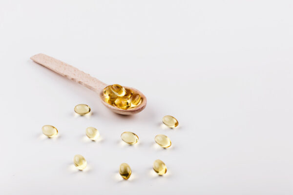 lepel met omega 3 visolie supplementen met een witte achtergrond