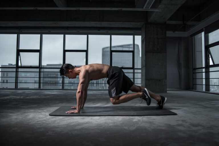 Fitte man doet bergbeklimmersoefeningen in een moderne sportschool voor een Body en fit review