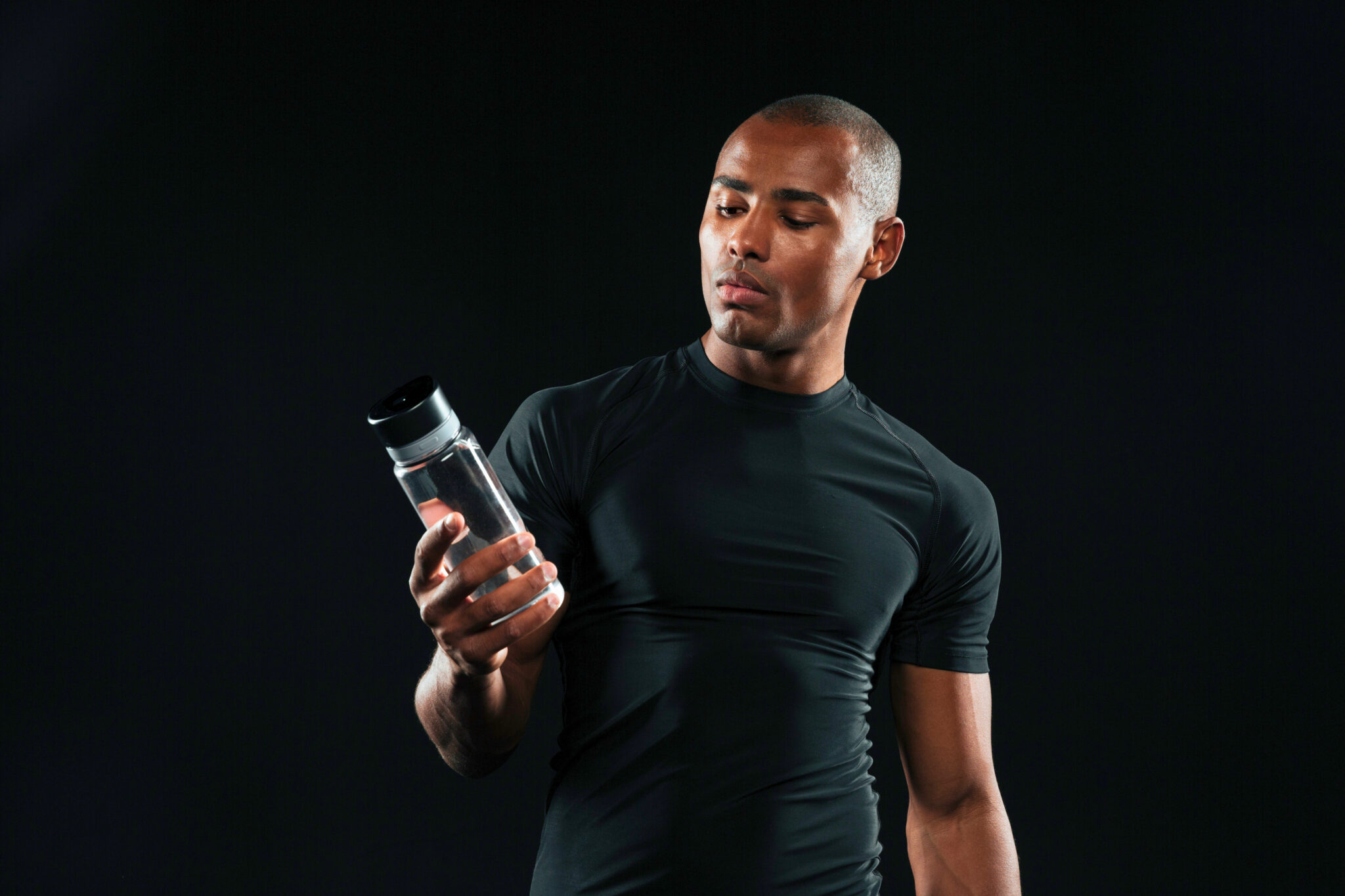 Een man die kijkt naar een fles pre-workout