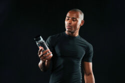 Een man die kijkt naar een fles pre-workout