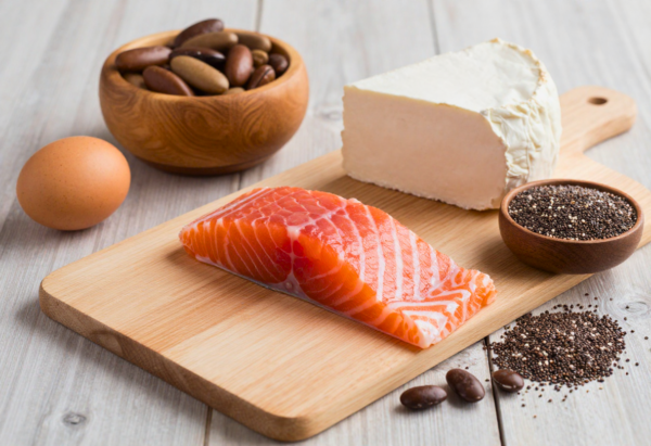 verschillende eiwitrijke producten dichtbij, plakjes zalm, kalkoen, linzen, kwark, en chiazaad