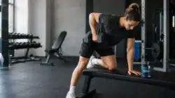 Sporter traint met een dumbbell naast een pot creatine monohydraat.