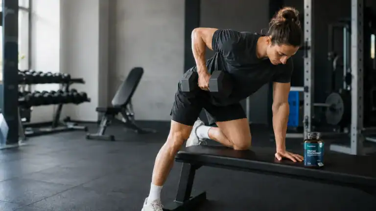 Sporter traint met een dumbbell naast een pot creatine monohydraat.